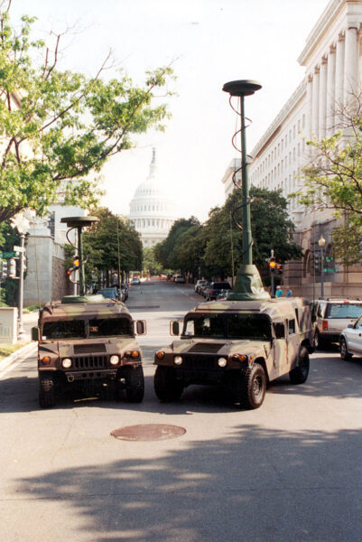 Two EXB telescopic masts deployed on camouflaged Humvees in front of the U.S. Capitol, supporting tactical communications during a security operation in Washington D.C.